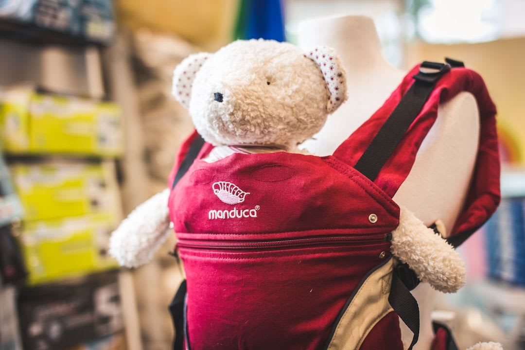 Verschiedene ergonomische Babytragen und Tragetücher auf einem Holztisch, als ideale Alternative bei Kinderwagen Verweigerung für Nähe und Entwicklung. | Foto: Baby Natur