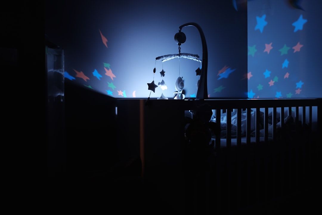 Ein leeres Bettchen nachts, beleuchtet von einem Monitor, symbolisiert Schlafprobleme, bei denen eine Schlafberatung hilft. | Foto: Bastien Jaillot