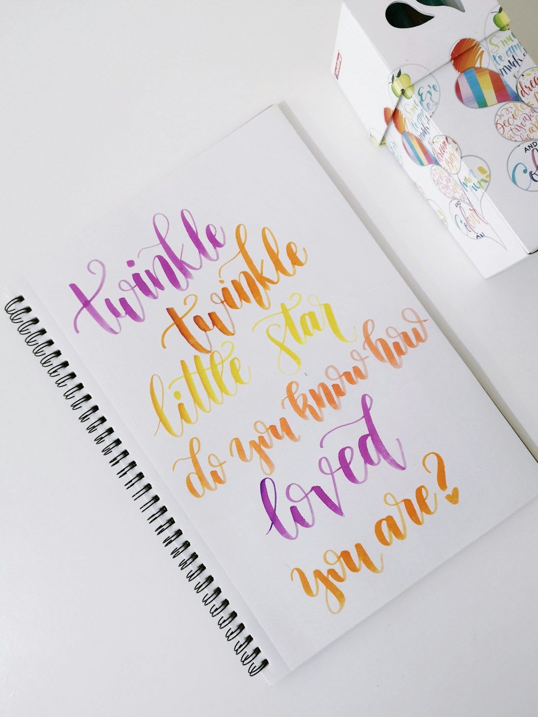 Offenes Notizbuch mit positiven Affirmationen, umgeben von weichen Stoffen und einer Tasse Tee, symbolisiert Unterstützung bei Stillproblemen. | Foto: camila waz