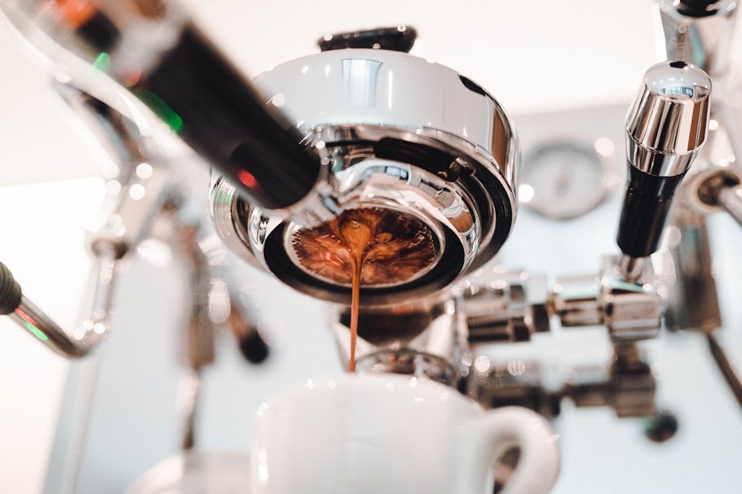 Ein Barista schäumt Milch für einen Cappuccino professionell in einem Edelstahlkännchen zu perfektem Milchschaum auf. | Foto: Charles Sims