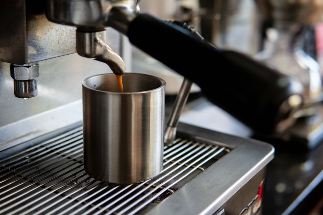 Ein Milchkännchen aus Edelstahl neben einem Espresso, wichtiges Equipment für die Kaffeezubereitung von Cappuccino oder Latte Macchiato. | Foto: Victor Rutka