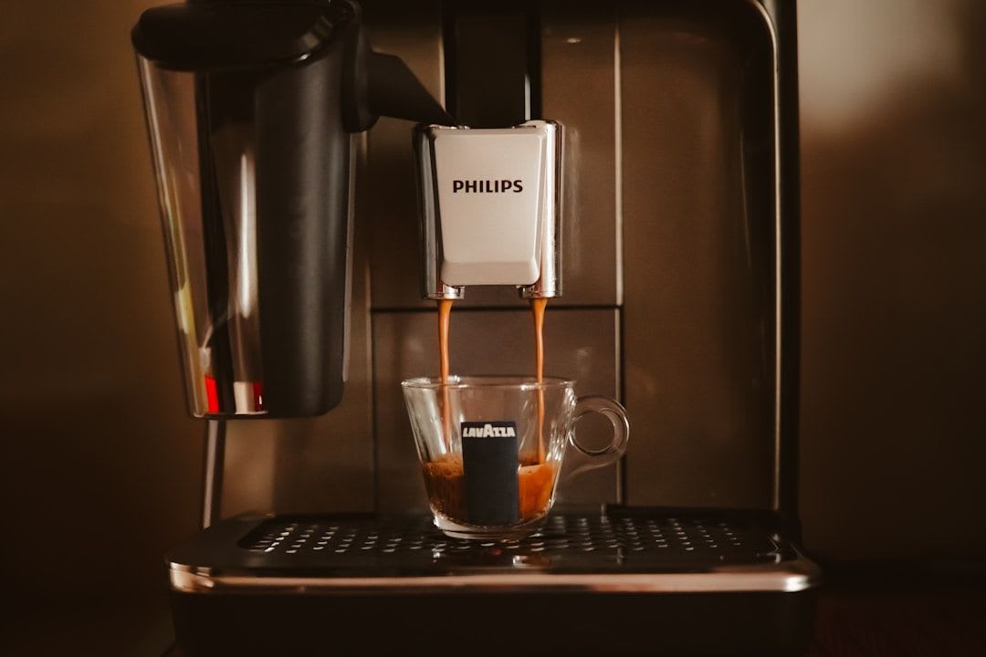 Philips Kaffeevollautomat während des Entkalkungsvorgangs, bei dem Flüssigkeit in einen Auffangbehälter läuft. | Foto: Ile Ristov