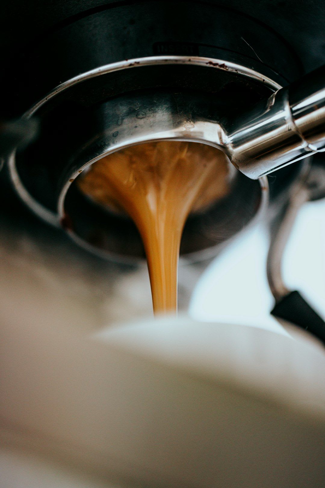 Nahaufnahme von Kaffeemehl im Siebträger während der Preinfusion, die für mehr Aroma und einen komplexen Espresso-Geschmack sorgt. | Foto: Nathan Dumlao